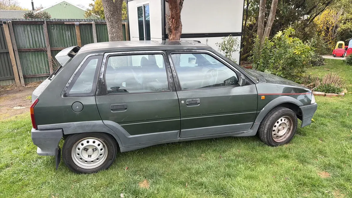 Sam Frost’s dark green Citroën AX GT parked on a lawn